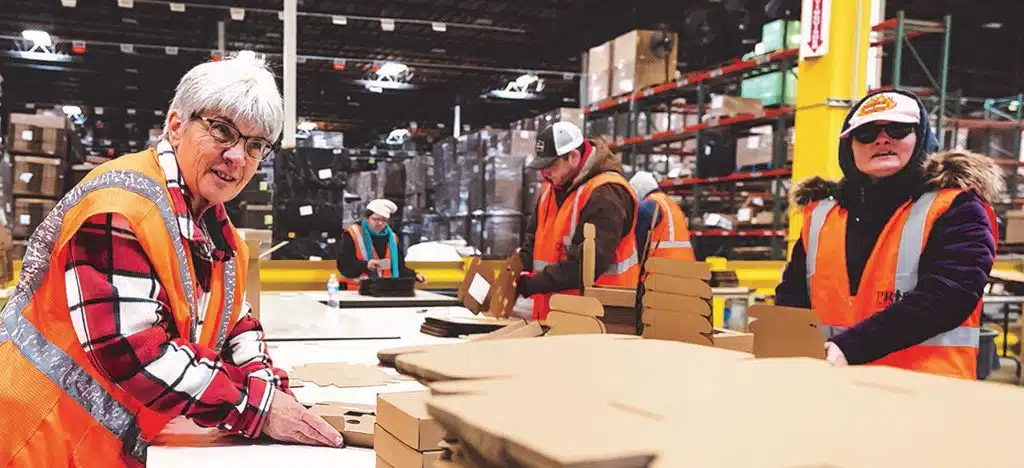 several workers in a warehouse packaging orders